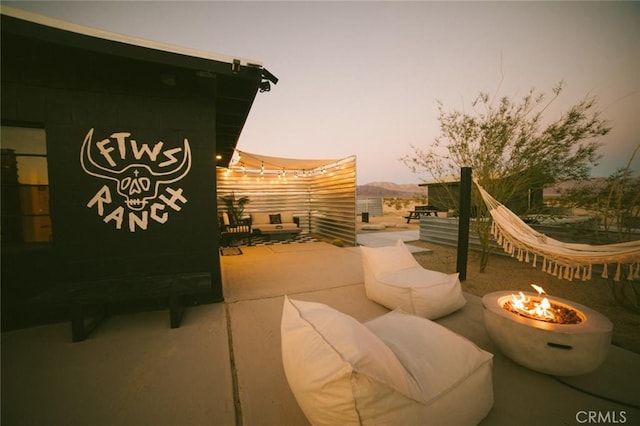 patio terrace at dusk featuring an outdoor fire pit