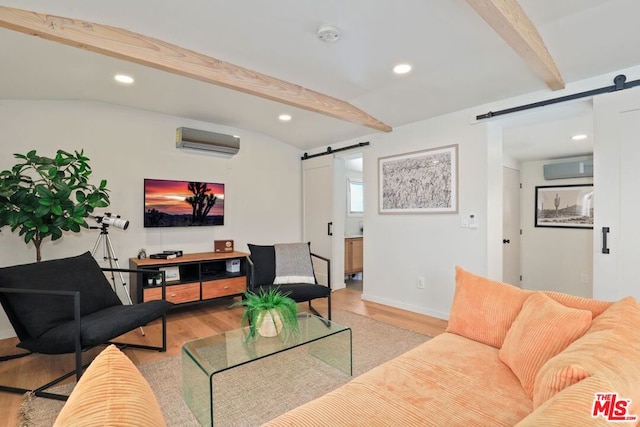 living room featuring beamed ceiling, light wood-type flooring, a barn door, and a wall mounted AC