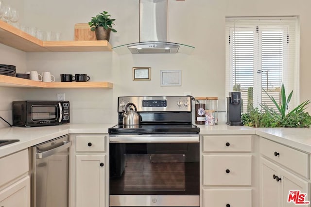 kitchen featuring white cabinetry, island exhaust hood, and appliances with stainless steel finishes