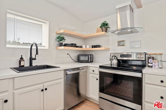 kitchen featuring appliances with stainless steel finishes, light wood-type flooring, ventilation hood, sink, and white cabinets