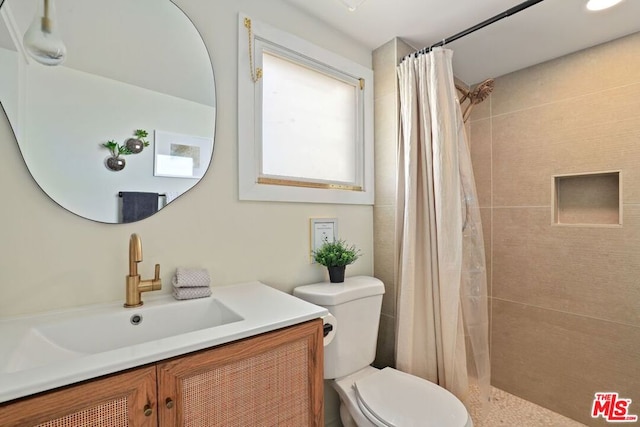 bathroom with a shower with shower curtain, vanity, and toilet