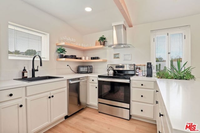 kitchen with island exhaust hood, light wood-type flooring, stainless steel appliances, sink, and white cabinetry