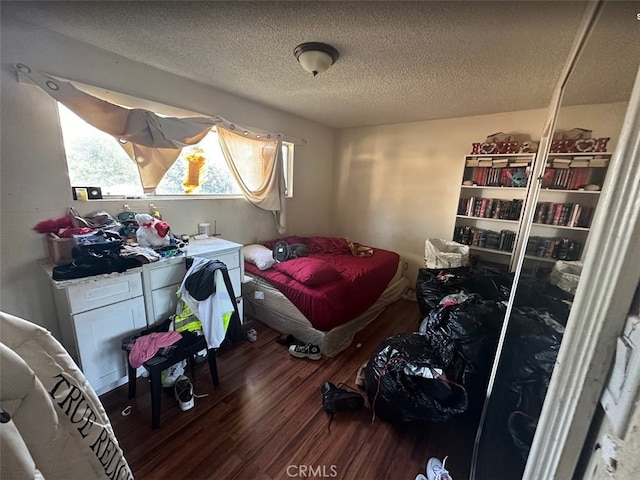 bedroom with dark hardwood / wood-style flooring and a textured ceiling