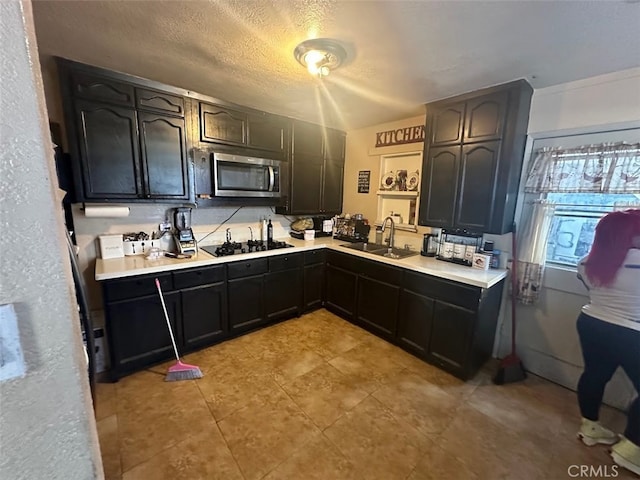 kitchen with a textured ceiling, black gas cooktop, and sink