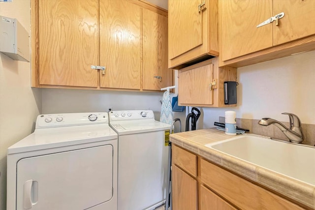 laundry area with sink, washing machine and dryer, and cabinets