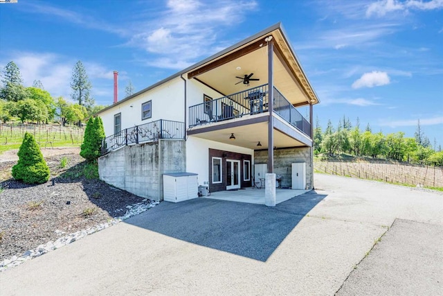 rear view of property featuring a patio area and ceiling fan