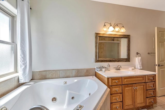 bathroom featuring vanity, a relaxing tiled tub, and tile patterned flooring