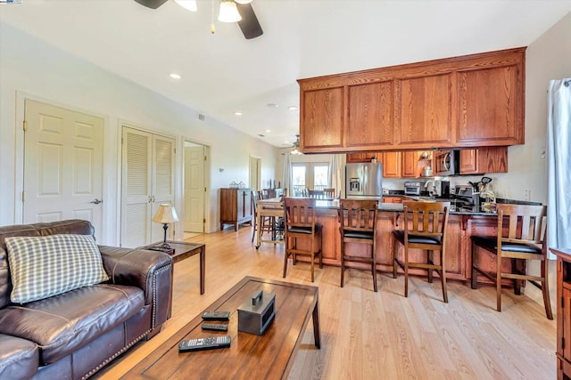 living room featuring ceiling fan and light wood-type flooring