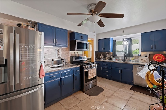 kitchen with ceiling fan, backsplash, stainless steel appliances, sink, and blue cabinets