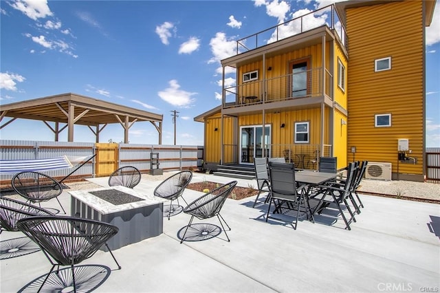 view of patio featuring a balcony, an outdoor fire pit, and ac unit