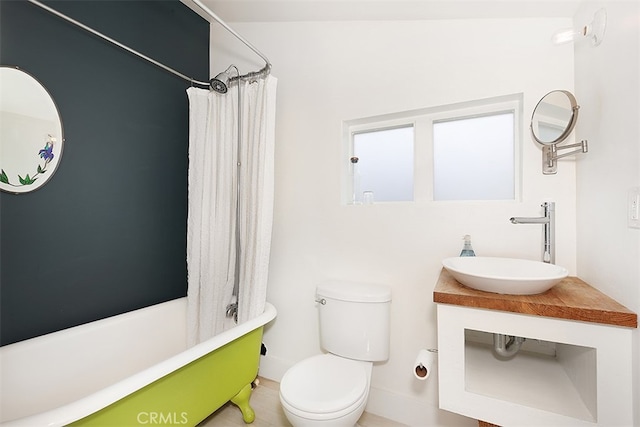 full bathroom featuring tile patterned floors, shower / bath combo with shower curtain, vanity, and toilet