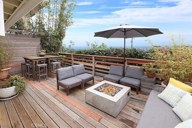 wooden deck featuring an outdoor living space with a fire pit