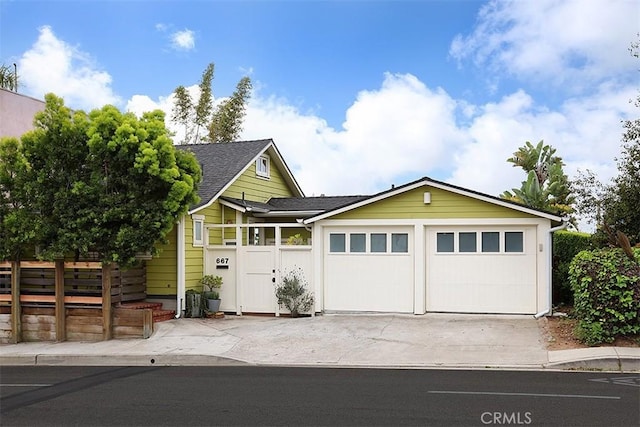 667 Glenneyre St, Laguna Beach, CA 92651 - view of front of house with roof with shingles, concrete driveway, fence, and an attached garage