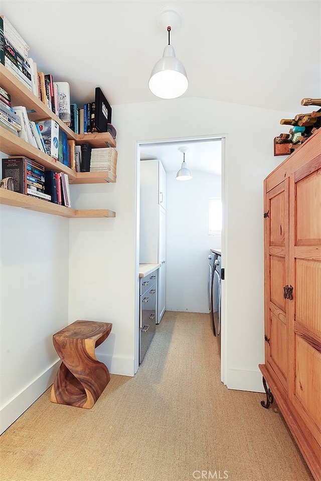 clothes washing area with washer and clothes dryer and light colored carpet