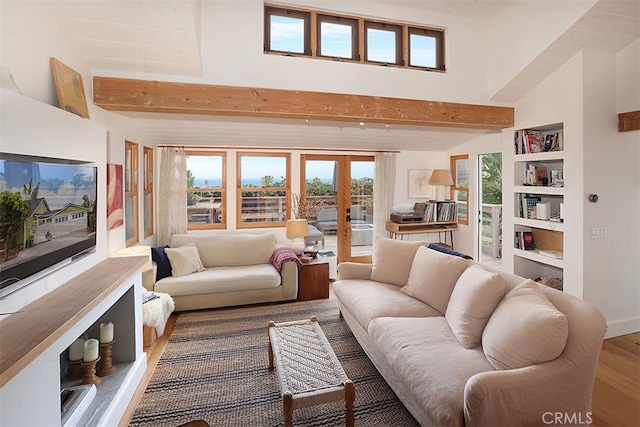 living room with hardwood / wood-style floors, beamed ceiling, and french doors