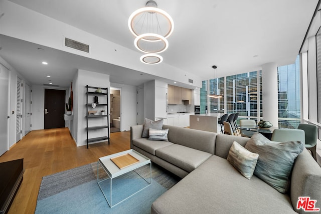 living room featuring floor to ceiling windows, light hardwood / wood-style flooring, and a notable chandelier