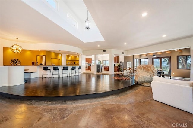 unfurnished living room featuring ceiling fan with notable chandelier