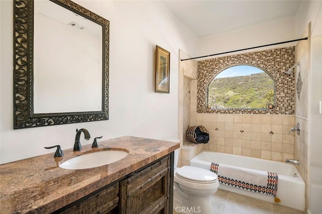 full bathroom with tile patterned flooring, vanity, tiled shower / bath combo, and toilet