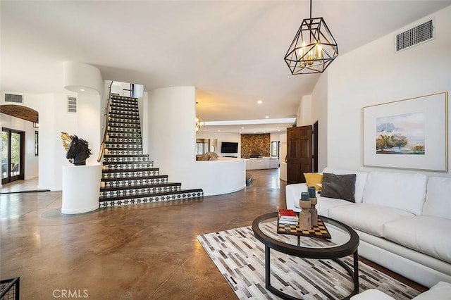 living room featuring a chandelier and concrete floors