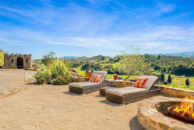 view of patio / terrace featuring an outdoor stone fireplace and a fire pit