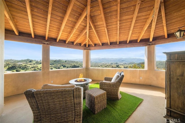 sunroom with a mountain view, vaulted ceiling with beams, and wood ceiling