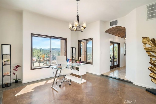 office featuring french doors, a healthy amount of sunlight, concrete flooring, and a notable chandelier