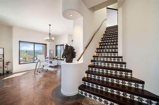 stairway featuring concrete floors and an inviting chandelier