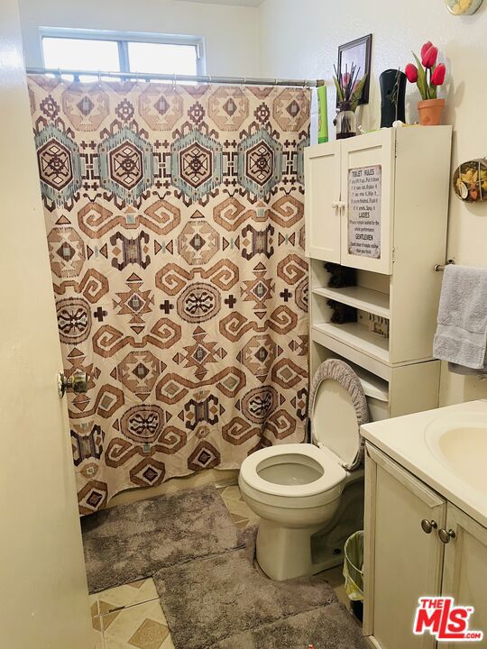 bathroom with vanity, toilet, and tile flooring