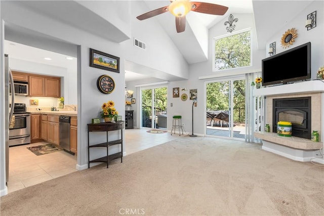 living room featuring plenty of natural light, high vaulted ceiling, and light carpet