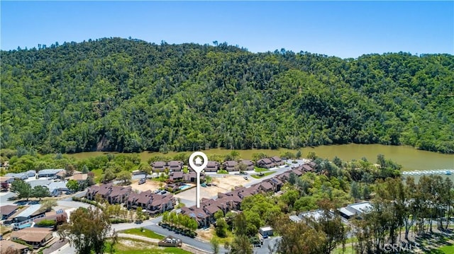 drone / aerial view featuring a residential view, a view of trees, and a water view