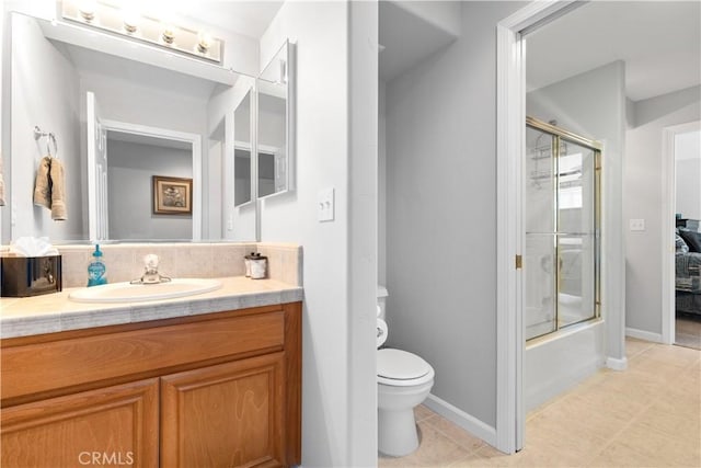 bathroom with tile patterned flooring, vanity, toilet, baseboards, and combined bath / shower with glass door
