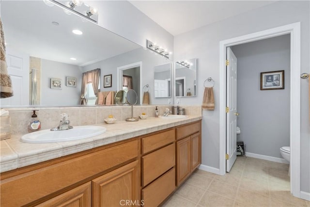 bathroom featuring vanity, decorative backsplash, and toilet