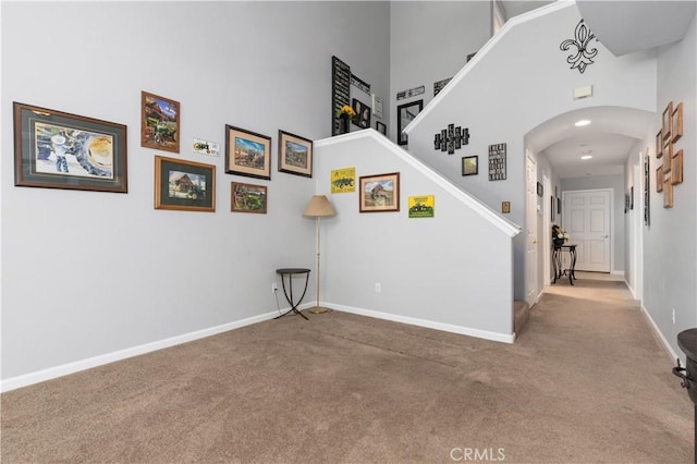 interior space featuring a towering ceiling and carpet floors