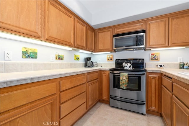 kitchen featuring stainless steel appliances and light tile patterned floors