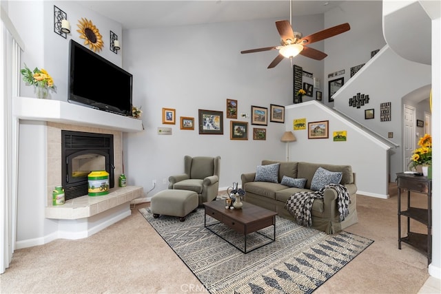 living room with ceiling fan, high vaulted ceiling, and light carpet