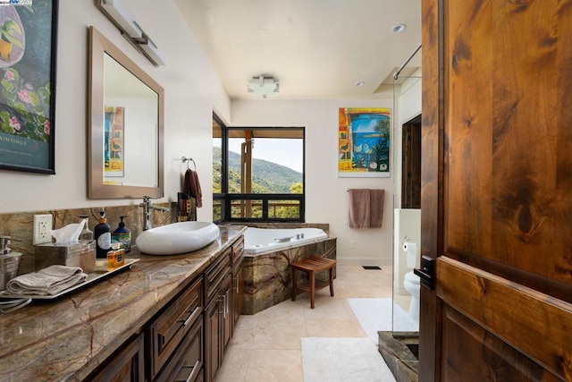 bathroom featuring a tub to relax in, vanity, a mountain view, toilet, and tile patterned floors