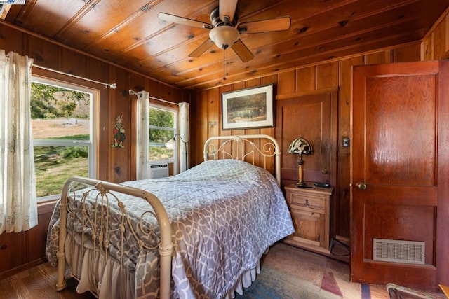 bedroom with wood walls, ceiling fan, and hardwood / wood-style flooring