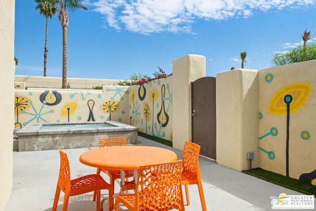 view of patio featuring an in ground hot tub