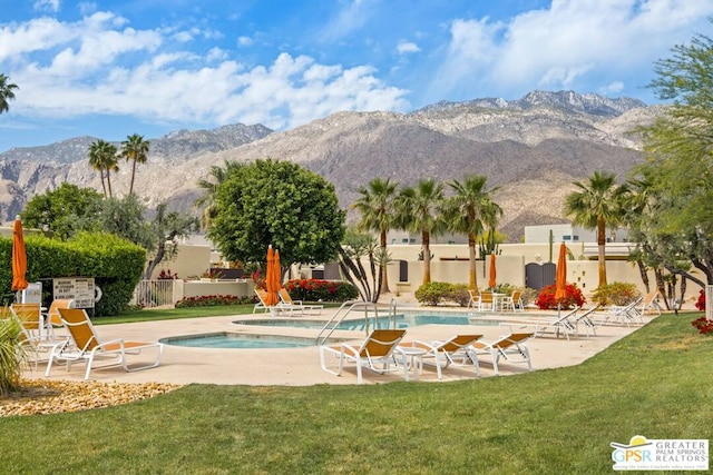 view of pool featuring a patio, a mountain view, and a yard