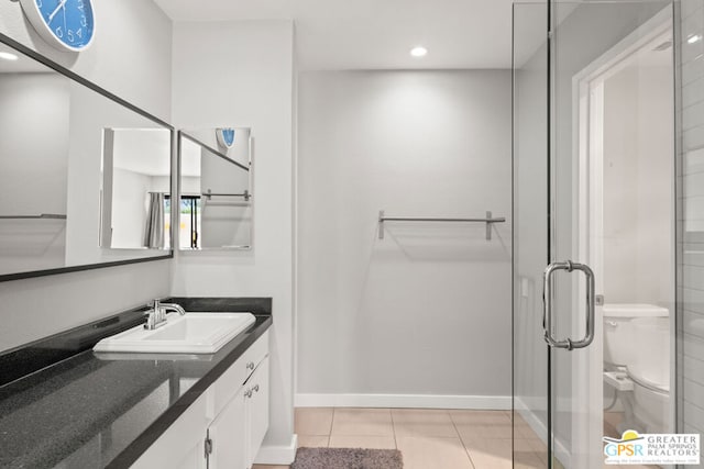 bathroom with walk in shower, vanity, tile patterned flooring, and toilet