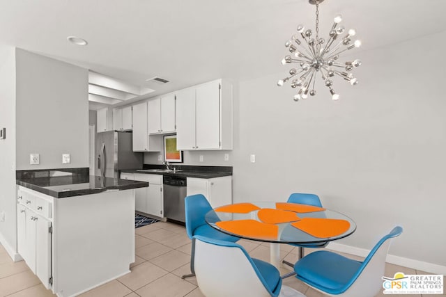 kitchen with white cabinets, light tile patterned floors, sink, a chandelier, and appliances with stainless steel finishes