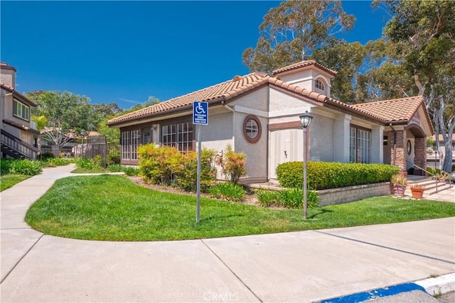 mediterranean / spanish house featuring a front lawn