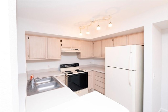 kitchen featuring white appliances, sink, and light brown cabinetry