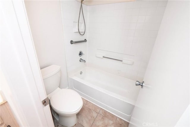 bathroom with tile patterned flooring, toilet, and tiled shower / bath