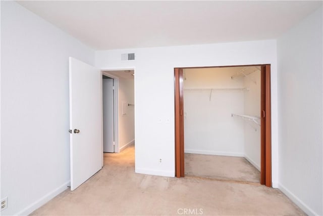 unfurnished bedroom featuring light carpet and a closet