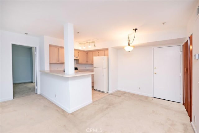 kitchen with white refrigerator, light brown cabinetry, decorative light fixtures, light colored carpet, and kitchen peninsula