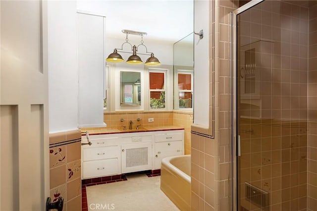 bathroom with vanity, tile patterned flooring, plus walk in shower, and tile walls