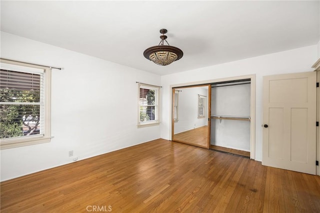 unfurnished bedroom featuring a closet and hardwood / wood-style flooring