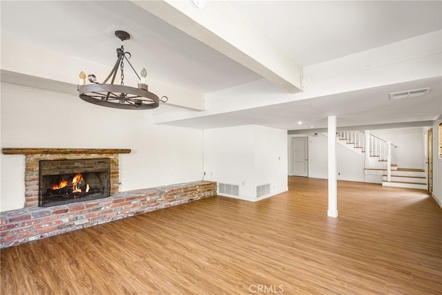 unfurnished living room with a fireplace, hardwood / wood-style floors, and beamed ceiling