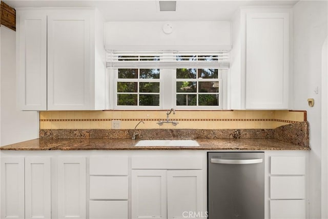 kitchen with backsplash, dark stone countertops, white cabinetry, and sink